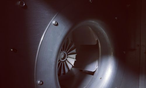 Nahaufnahme eines Ventilators oder Lüfters mit Flügelrad in einem dunklen technischen Gehäuse.